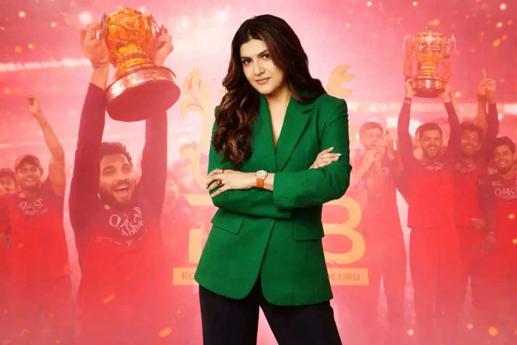 Ananya Birla in green blazer with RCB team celebrating IPL trophy in red background