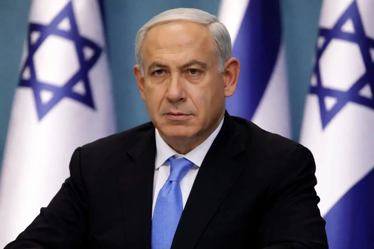Benjamin Netanyahu formal portrait with israeli flags background